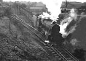 An unidentified ex-LMS 2-8-0 8F is seen at the head of an empty wagon train bound for Kingsbury Colliery