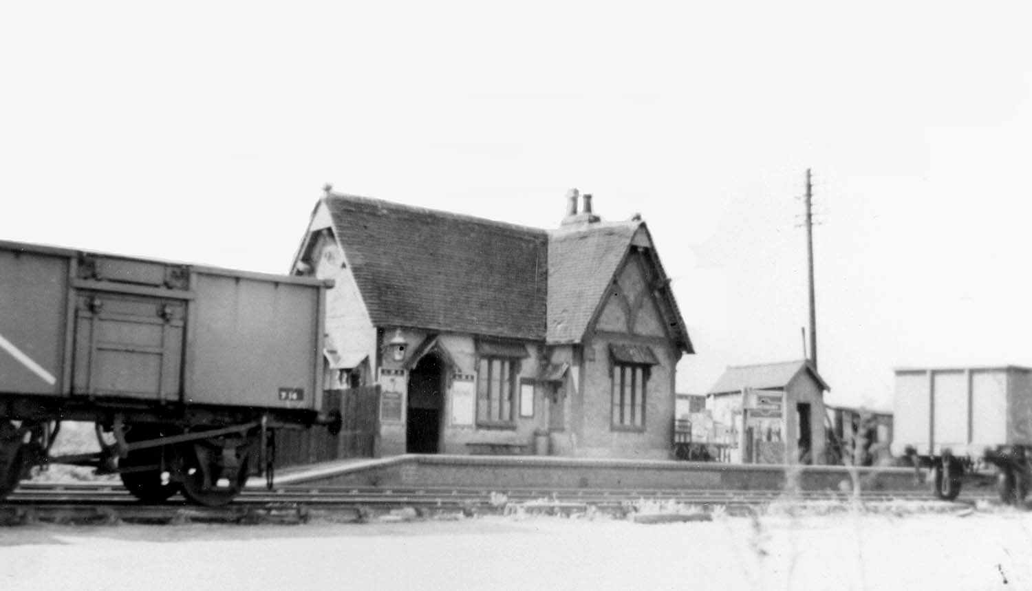 Looking from the down platform across to the station building whilst mineral wagons stand on the down line on 24th April 1952