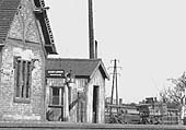 Close up showing one of the station's oil lamps, porters barrow with pigeon baskets and a timber storage hut