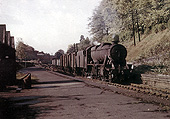 Ex-LMS 8F 2-8-0 No 48529 is passing through the derelict station on an up goods service on 11th October 1966