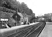 Looking towards Moseley with passengers waiting on the up platform as a goods train approaches the signal box