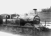 Ex-MR 1P 0-4-4T No 1324 stands at the head of a local					passenger train in the station