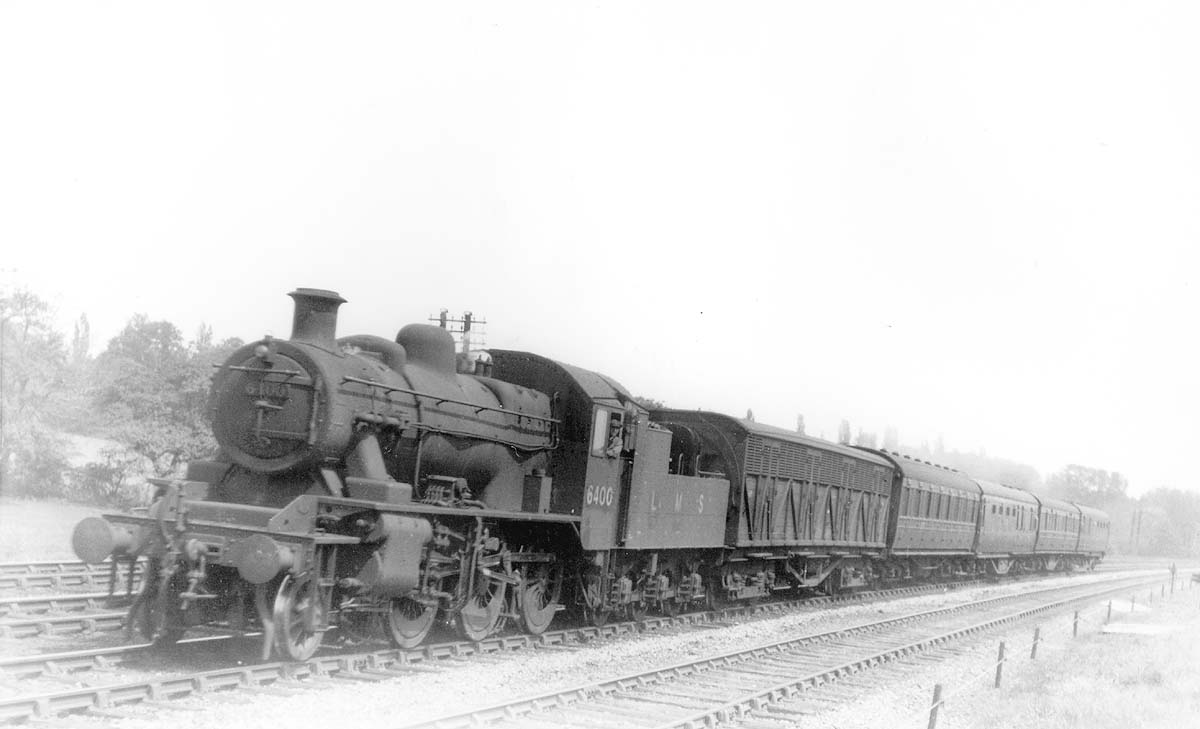 LMS 2-6-0 2MT No 6400 is seen heading a local passenger service made up of mixed coaching stock