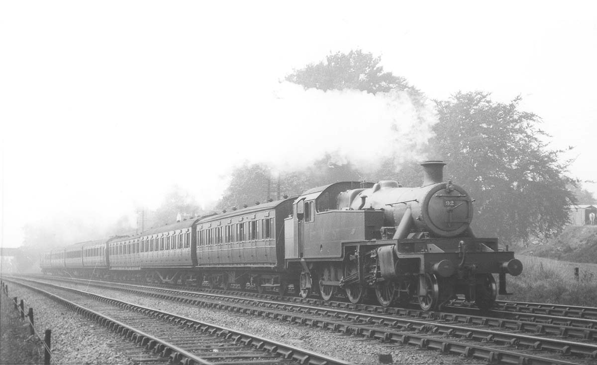 LMS Stanier 2-6-2T 3P No 92 is seen travelling at speed on a seven coach local passenger service in 1937