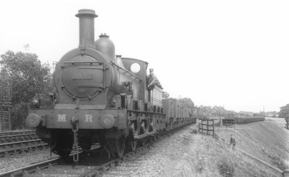The fireman leans out from the cab of MR Kirtley 0-6-0 No 2336 as she passes the carriage sidings