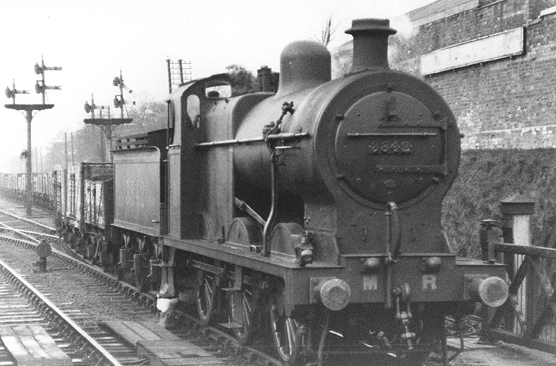 MR 0-6-0 4F No 3842 passes over Kings Norton level crossing as it draws forward a train of mineral wagons on to the up line