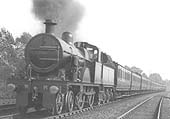 MR 4-4-0 3P No 768, converted for oil firing, is seen at the head of a down express train south of Kings Norton