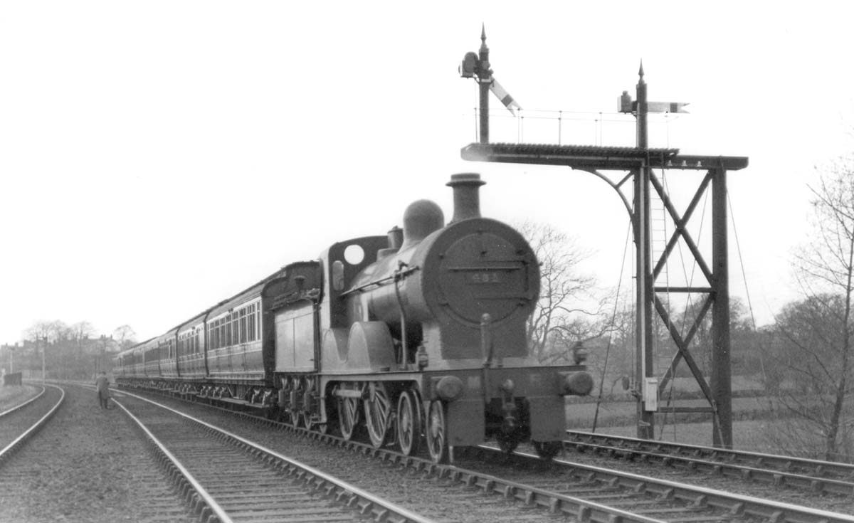 MR 4-4-0 No 431 on a down express passes the unusual MR signal gantry