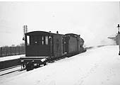 An unidentified ex-LMS 0-6-0 4F locomotive is seen towing a guards or 'brake' van through Kings Norton Station in the winter of 1961