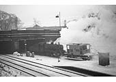 British Railways built 2MT 2-6-0 No 46443 runs through Kings Norton station tender first with a brake van in tow