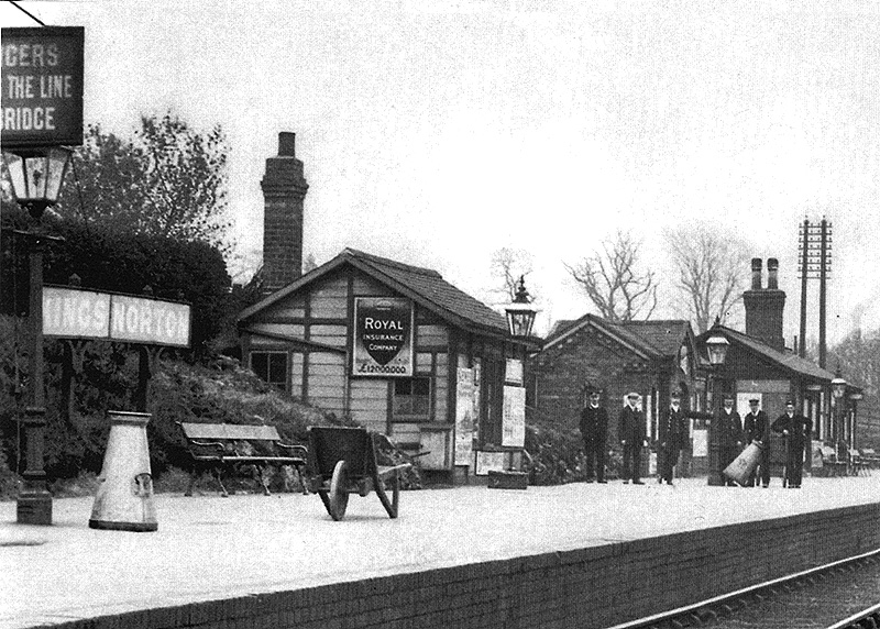 Station staff pose for the camera on Norton station's up platform whilst moving milk churns