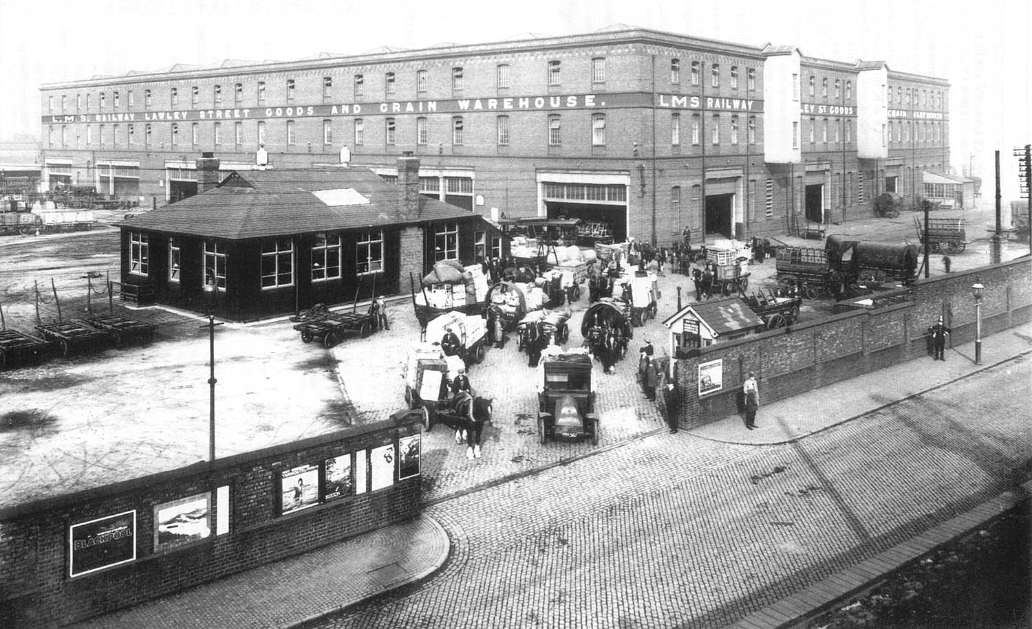 A posed photo taken on 11th July 1910 of the Landor Street entrance to the goods shed and a variety of road vehicles