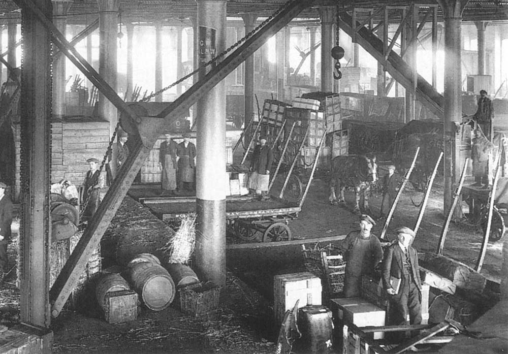 A close up showing the transfer of goods to horse drawn road vehicles for onward transportation