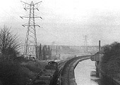 View of an unidentified ex-MR 0-6-0 locomotive at the head of a rake of open wagons as it traverses the canal branch