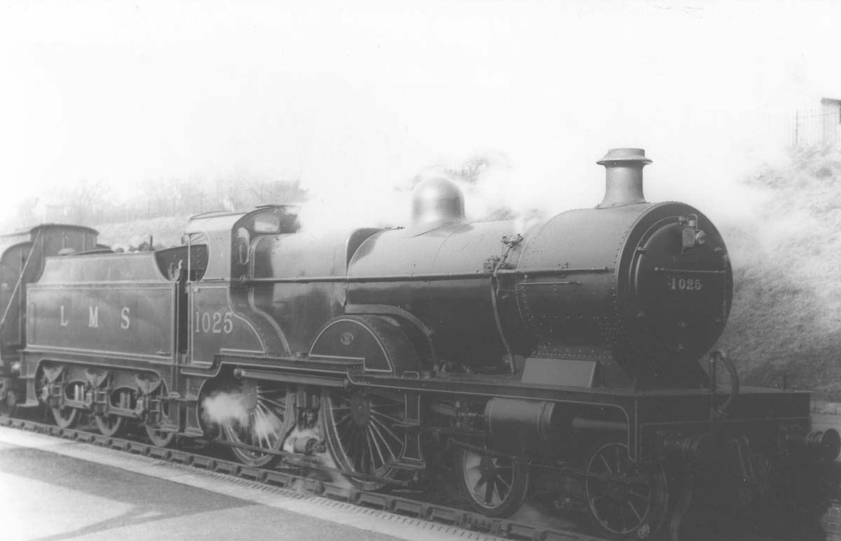 Ex-MR 4P 4-4-0 Compound No 1025 stands at the head of a local passenger train