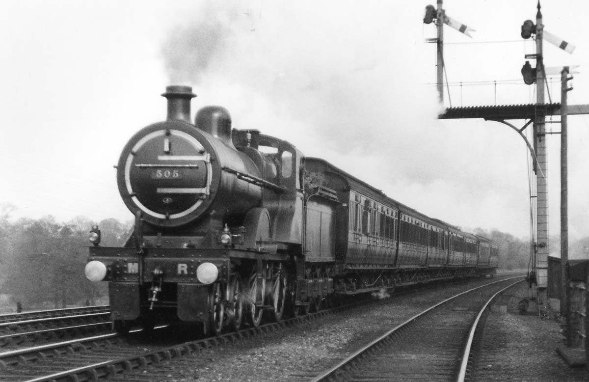 MR 2P 4-4-0 No 505 passes Midland Railway bracket signals whilst at the head of a seven coach express train