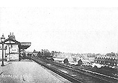 Looking towards Birmingham New St with station staff posed outside the main station building on the down platform