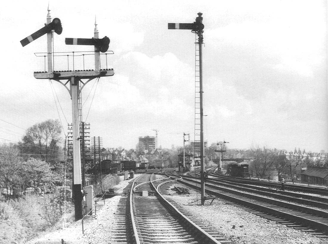 View of Northfield's MR timber bracket signal controlling the up goods line and the LMS tubular steel signal controlling the up main line