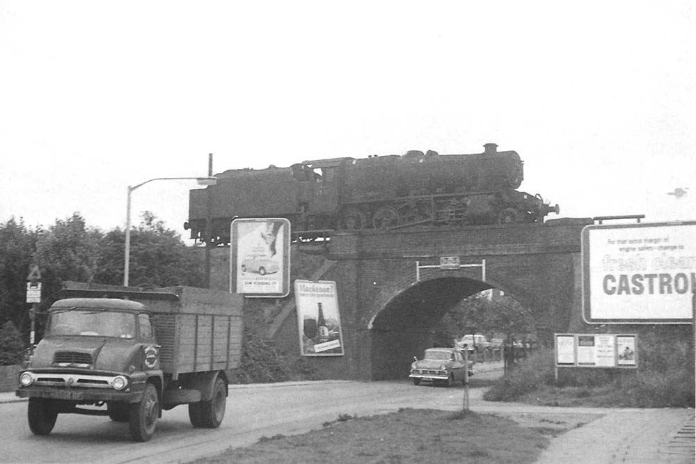 Ex-LMS 8F 2-8-0 No 48713 runs light engine tender first over the A444 on its way to pick up its train in Abbey Street sidings in early 1966