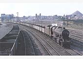 Ex-LMS 8F 2-8-0 No 48053 heads a long rake of steel bodied mineral wagons on a Leicester bound service