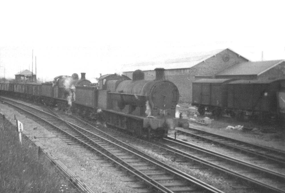 Ex-LNWR 0-8-0 7F No 49120 and classmate No 48927 pass Abbey Street goods yard with a coal train from Ashby