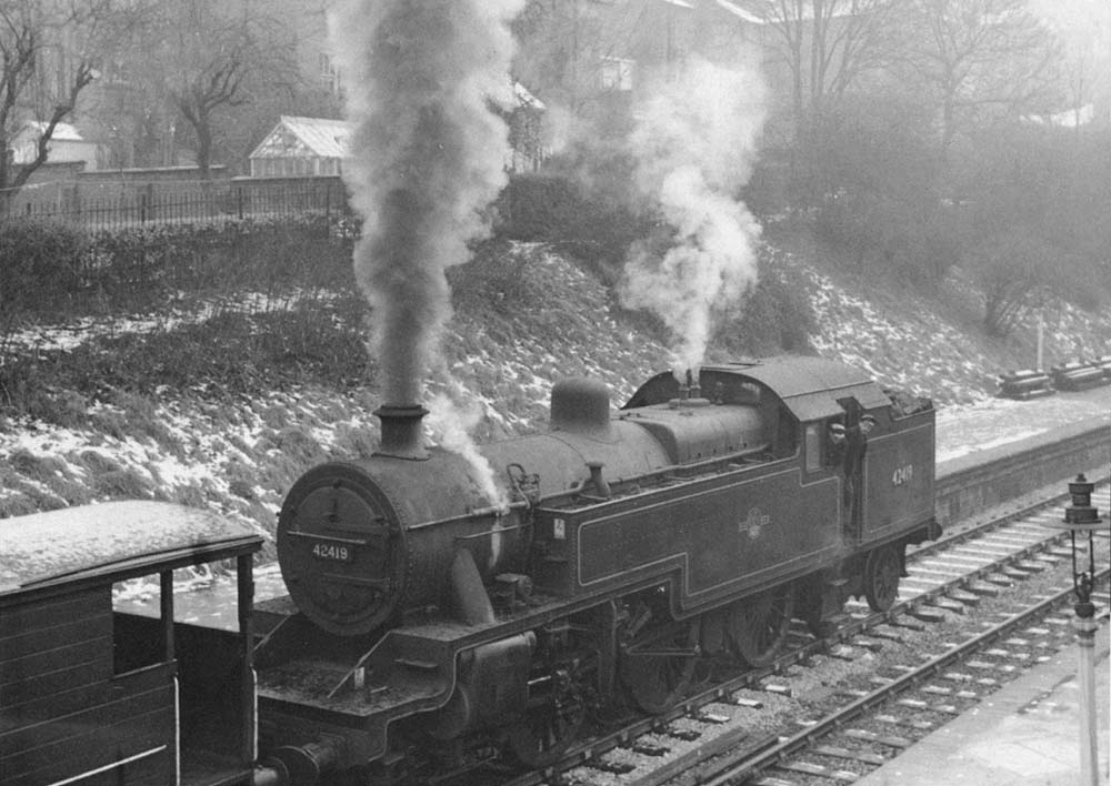 Ex-LMS 4P 2-6-4T No 42419 is seen running through the station bunker first on a down freight
