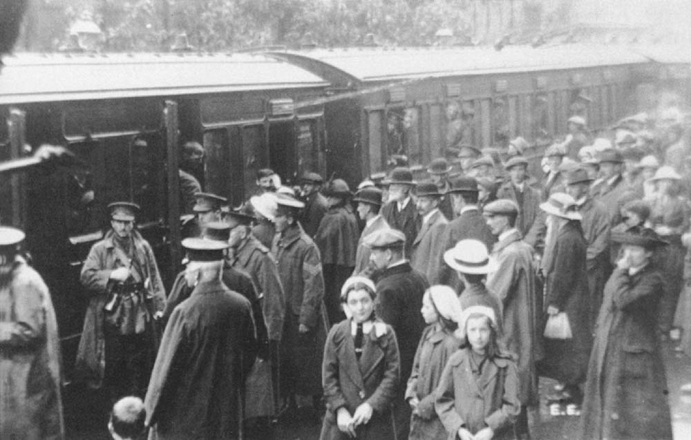 A train of army personnel wait to depart from Redditch station in 1914 as their family and friends look on