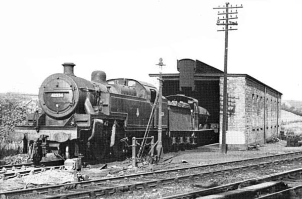 Ex-LMS Fowler 2-6-4T No 42334 and an unidentified ex-MR 3F 0-6-0 goods engine stand outside the single road engine shed