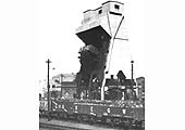 View of Saltley shed's mechanical coaling plant showing both a range of different railway company wagons and a wagon being hoisted to the top for tipping