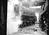 British Railways Standard Class Crosti-boilered 9F 2-10-0 No 92029 is wreathed in steam as it prepares to depart the roundhouse