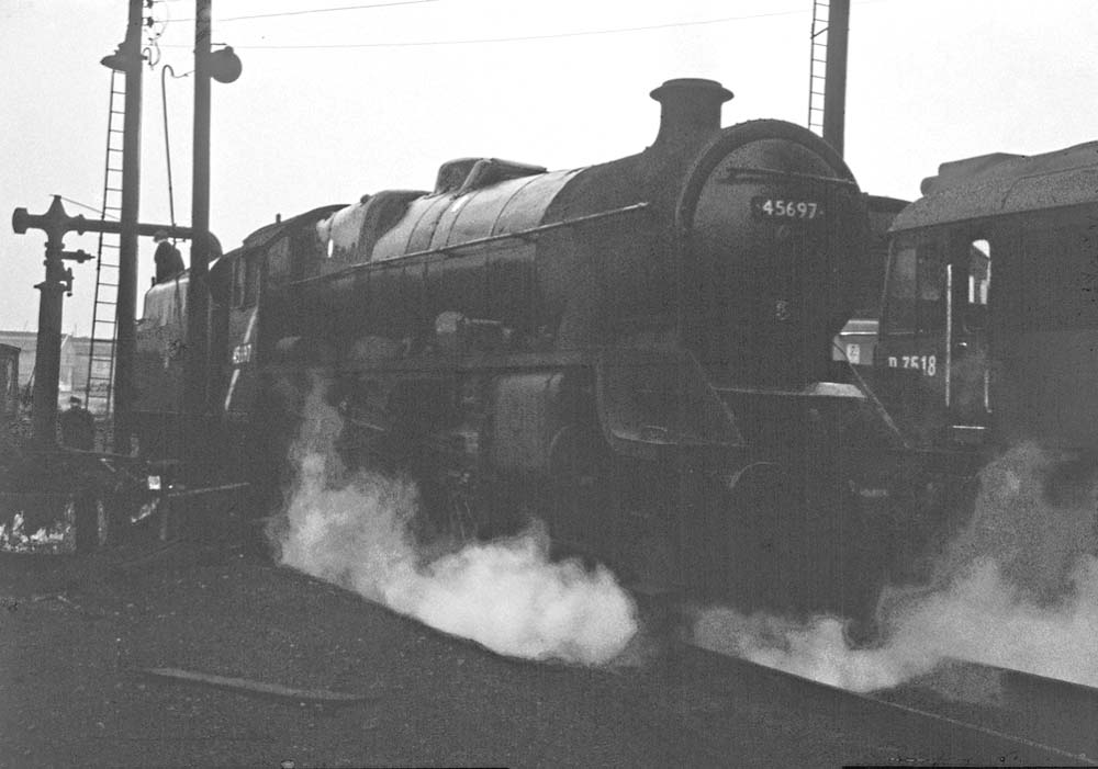 Ex-LMS 5XP 4-6-0 No 45697 'Achilles' is seen topping up her tender with water at Saltley shed