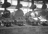 BR Standard and ex-LMS locomotives, including 5MT 4-6-0 No 44965, stand inside one of the roundhouses