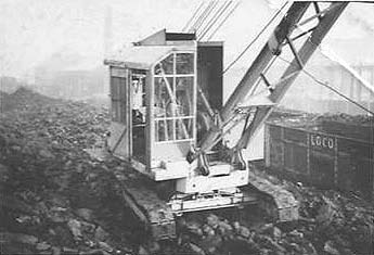 A crawler crane is seen loading coal from Saltley shed's coal stack into 'Loco' wagons to be taken to the Coaling Tower