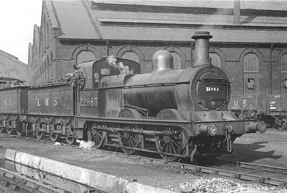 Ex-MR 2F 0-6-0 No 22983 is seen standing at the corner of Saltley shed's No 3 roundhouse with steam drifting from its safety valves