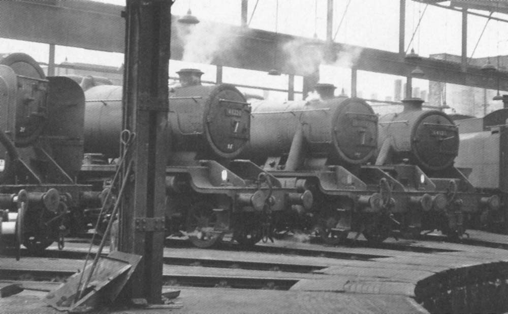An internal view of one of Saltley shed's rebuilt roundhouses with two ex-LMS 8Fs, a BR Standard 9F and an ex-LMS Black 5 on show around the turntable