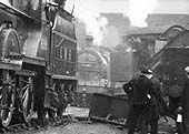 Close up showing railwaymen looking on as Saltley shed's breakdown crane is being employed to the front of the No 3 roundhouse