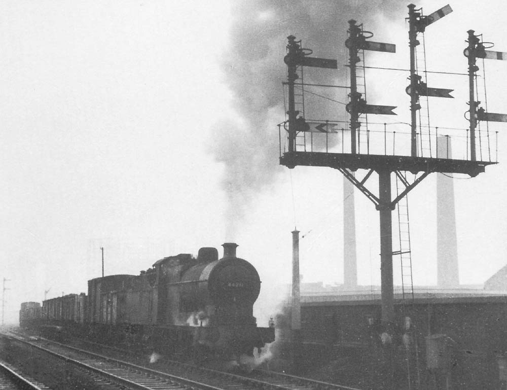 Ex-LMS 4F 0-6-0 No 44211 at the head of a down freight is held at signals on a grey day in March 1963