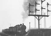 Ex-LMS 4F 0-6-0 No 44211 at the head of a down freight is held at signals on a grey day in March 1963