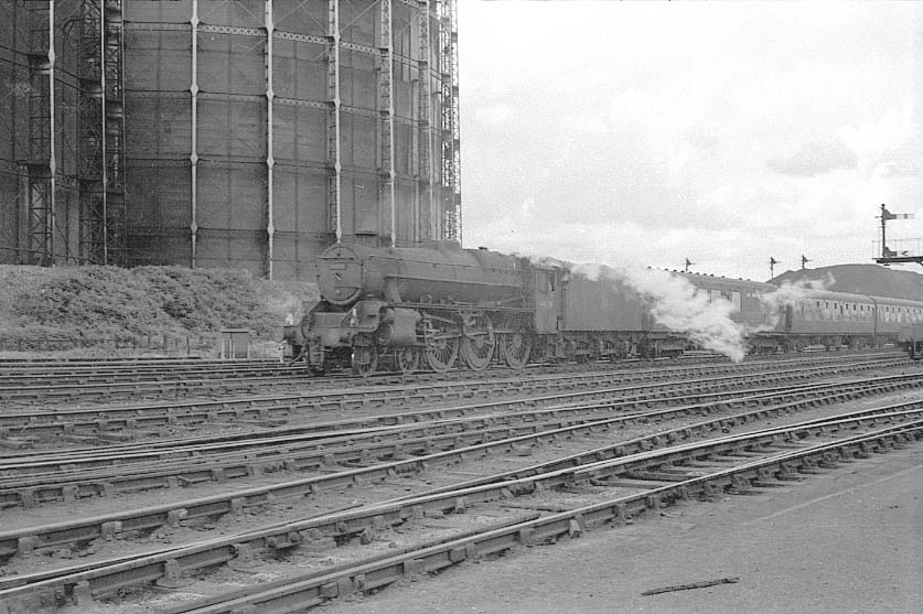 An unidentified ex-LMS Class 5 4-6-0 locomotive passes by Saltley Gas Works on westbound train in 1962