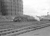 An unidentified ex-LMS Class 5 4-6-0 locomotive passes by Saltley Gas Works on westbound train in 1962