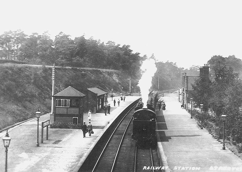 An unidentified Midland Railway tank locomotive, running bunker first, stands at the down platform on a local passenger service to New Street station