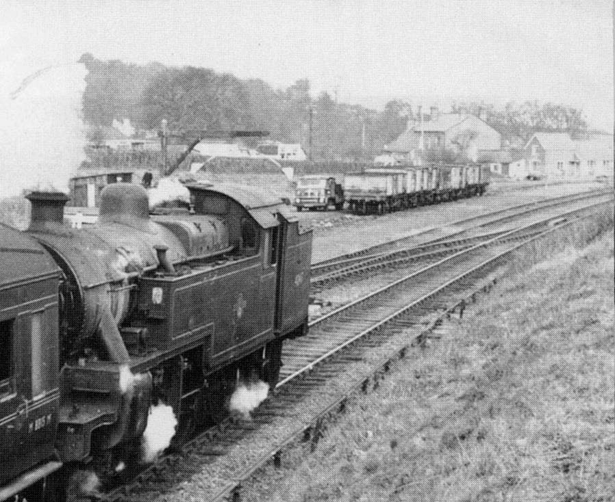 Close up showing a rake of mineral wagons being used to transport coal and a coal merchant's lorry being loaded