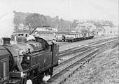 Close up showing a rake of mineral wagons being used to transport coal and a coal merchant's lorry being loaded