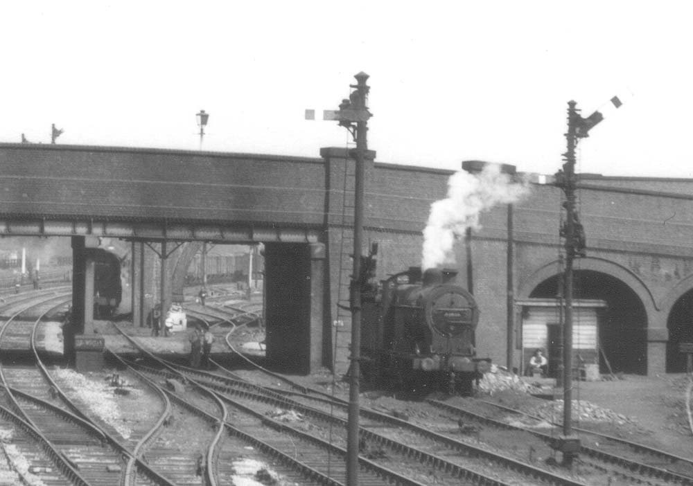 Close up showing a down goods train approaching whilst the ex-LMS 0-6-0 4F waits for the train to pass by before buffering up to the rear