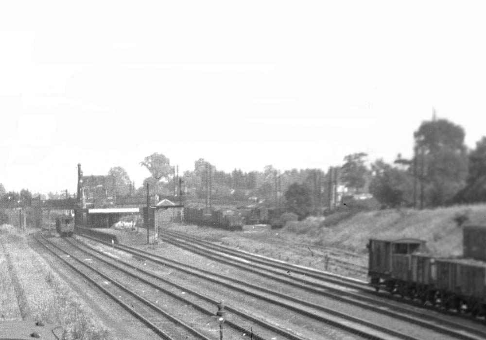 Close up showing Water Orton station's goods yard on the right with many vehicles evident on both sidings