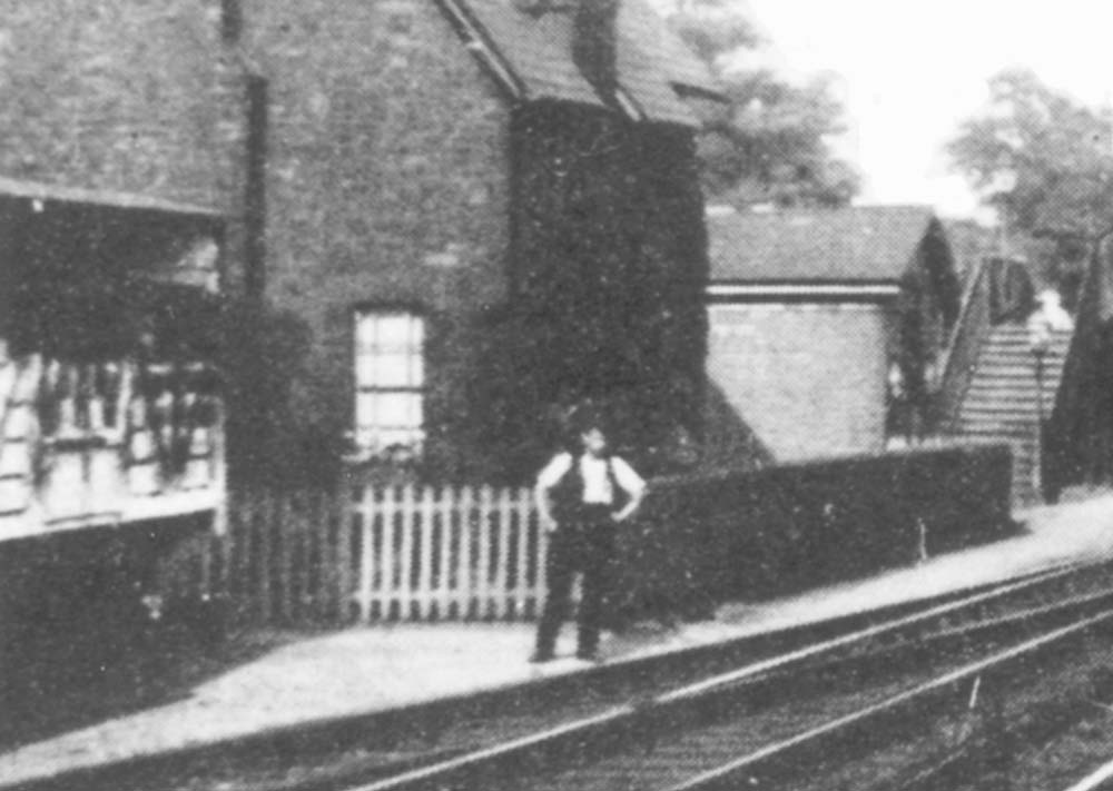 Close up showing the lime stained cattle wagon standing on the siding with a railway worker posed for the camera