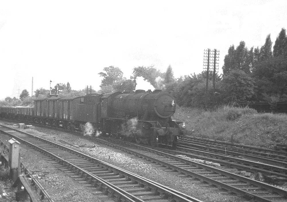 An unidentified ex-WD 2-8-0 locomotive approaches Water Orton from the Derby line on a Class F express freight service