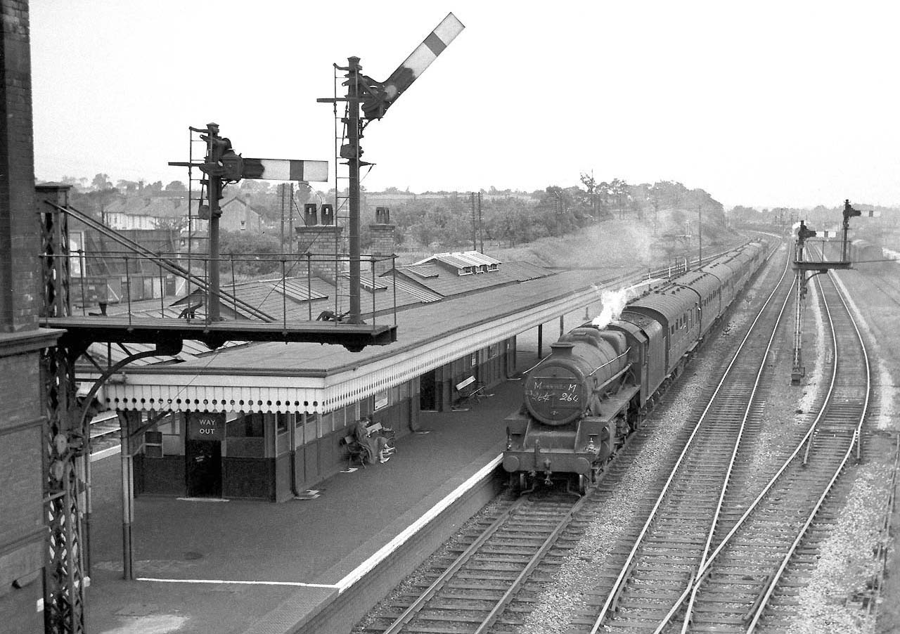 Ex-LMS 5MT 4-6-0 No 44918 heads a Class A express service through the station bound for Derby circa 1960