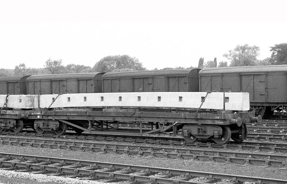 A British Railways Bogie Bolster 'C', No B943870, is seen loaded with a pre-stressed concrete beam at Water Orton circa 1959