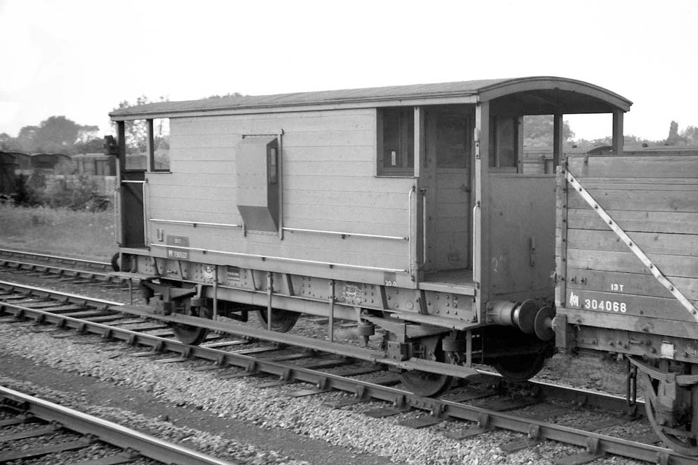 A former LMS 20 ton Goods Brake Van, No M730527, is seen attached to the rear of a passing up goods at Water Orton circa 1959